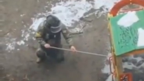 Thumbnail for A Ukrainian soldier in a protective suit carries an IED / Molotov cocktail to the children's playground. Then he sets it up, and the picture moves away. He then sends the photo to the authorities, which is then published with the story of "Russians mining playgrounds".