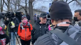 Thumbnail for Protesters throw a water bottle at a CNN crew member and hit him square on the head. They mock him when he falls down.